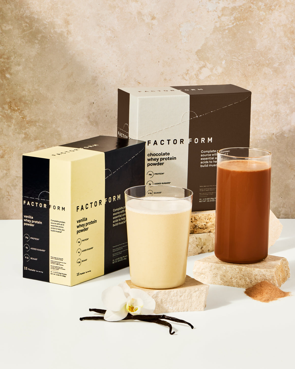 Factor Form protein packaging with two glasses of protein shakes on a neutral background