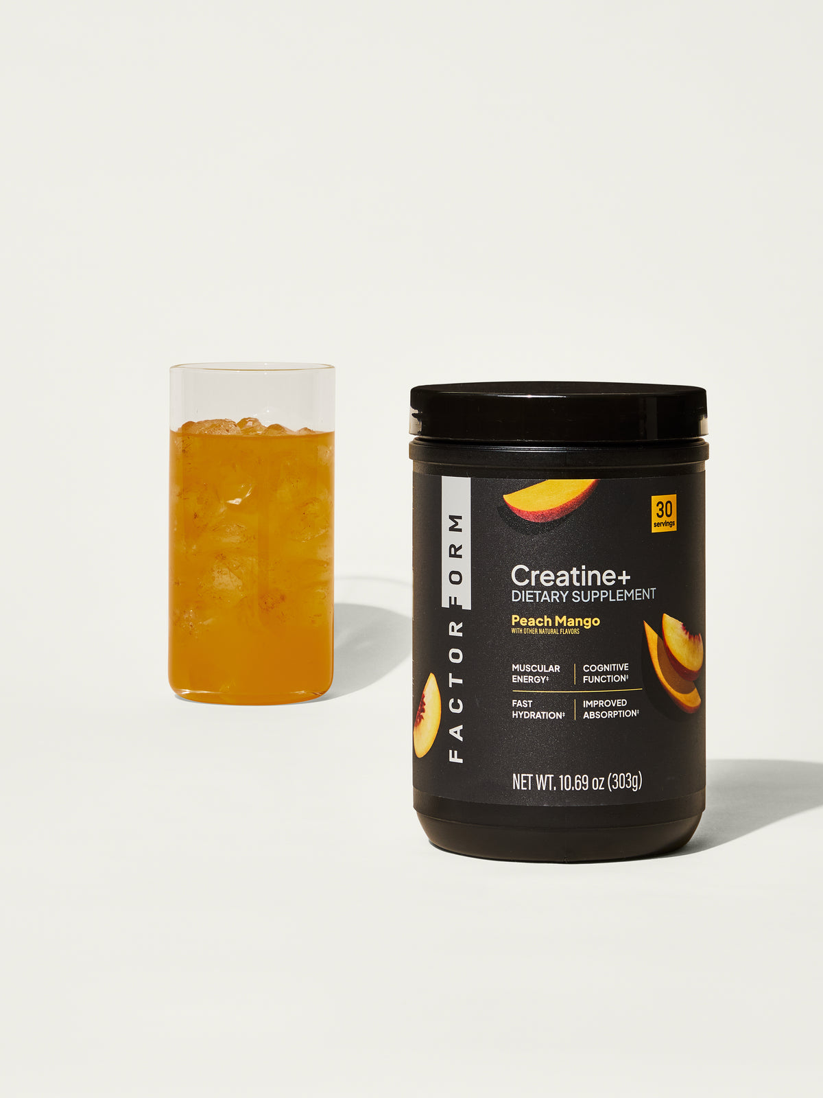 Creatine supplement container with peach mango flavor next to a glass on a white background